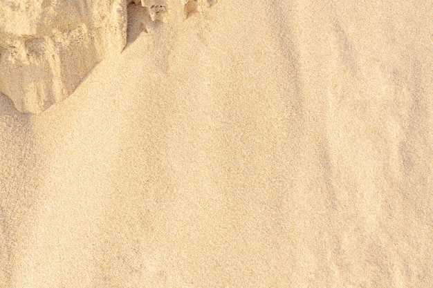 Fondo di struttura della sabbia. Modello del deserto marrone dalla spiaggia tropicale. Avvicinamento.