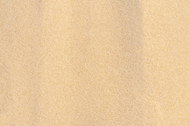 Fondo di struttura della sabbia sulla spiaggia. Reticolo di struttura della sabbia di mare beige chiaro, sfondo spiaggia sabbiosa.