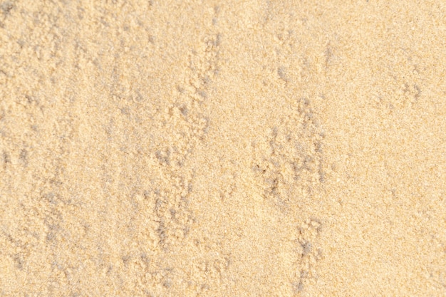 Fondo di struttura della sabbia sulla spiaggia. Reticolo di struttura della sabbia di mare beige chiaro, sfondo spiaggia sabbiosa.