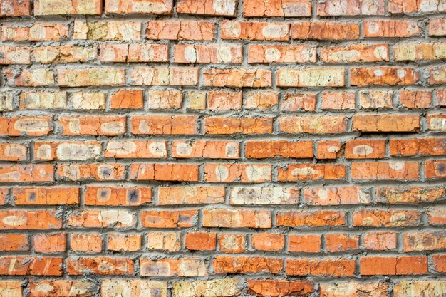 Fondo di vecchio muro di mattoni sporco d&#39;annata con il gesso della sbucciatura