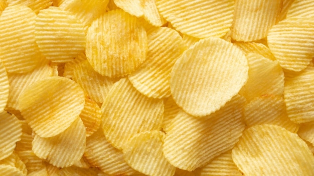 Fondo dorato croccante di struttura dello spuntino delle patatine fritte