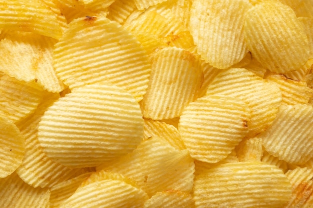 Fondo dorato croccante di struttura dello spuntino delle patatine fritte