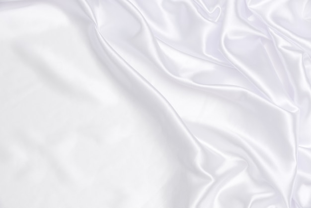 Fondo e struttura bianchi e luminosi del tessuto, sgualciti di raso bianco per l&#39;estratto e progettazione