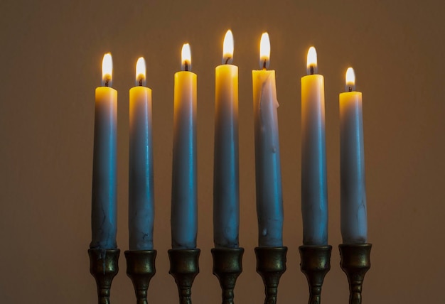 Fondo ebreo di Chanukah di festa con i candelabri tradizionali del menorah e le candele brucianti
