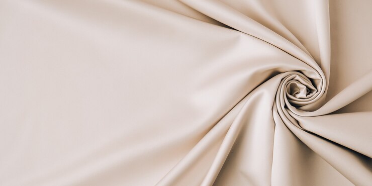 Fondo grigio del modello del tessuto, fondo grigio di struttura del tessuto d'ondeggiamento di progettazione. Seta o satinata color champagne color oro. Copia spazio per il testo. Sfondo trama