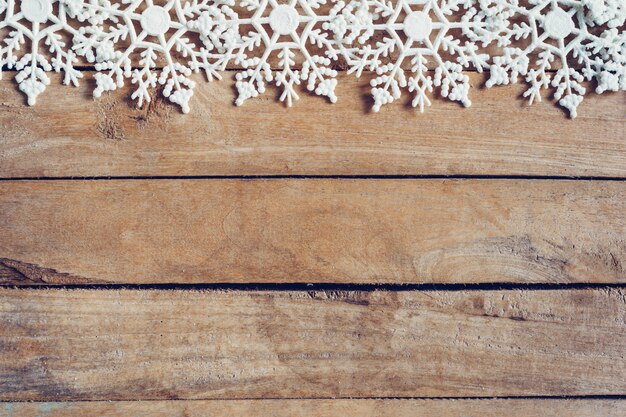 Fondo marrone di legno di natale con i fiocchi di neve e la decorazione di natale.