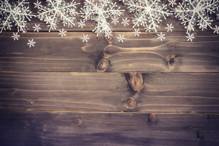 Fondo marrone di legno di natale e fiocchi di neve bianchi con spazio.