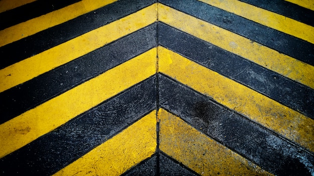Fondo nero e giallo di avvertimento del patten di avvertenza sul pavimento.