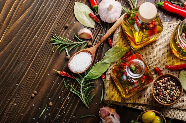 Fondo piatto di cibo fatto di oli condimenti e spezie sul tavolo della cucina. Concetto di cucina