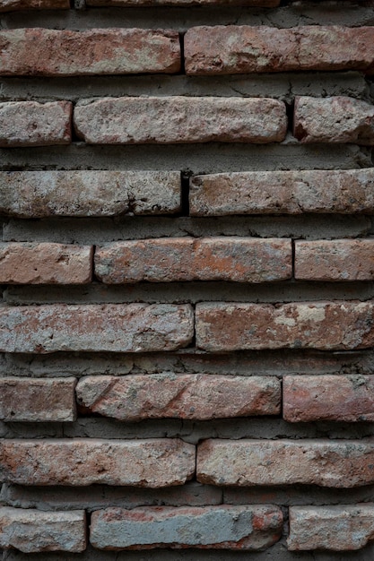 Fondo rosso di vecchia struttura del muro di mattoni dell'annata. Vista ravvicinata del vecchio muro di mattoni in pietra con muratura medievale, Foto di alta qualità