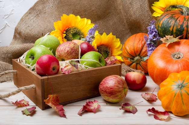 Fondo rustico di caduta con le foglie di autunno della zucca della scatola di legno mele verdi rosse