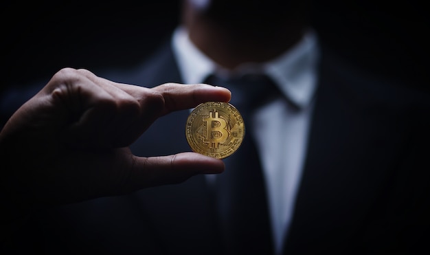 Fondo scuro di buio di Bitcoin della tenuta dell&#39;uomo d&#39;affari