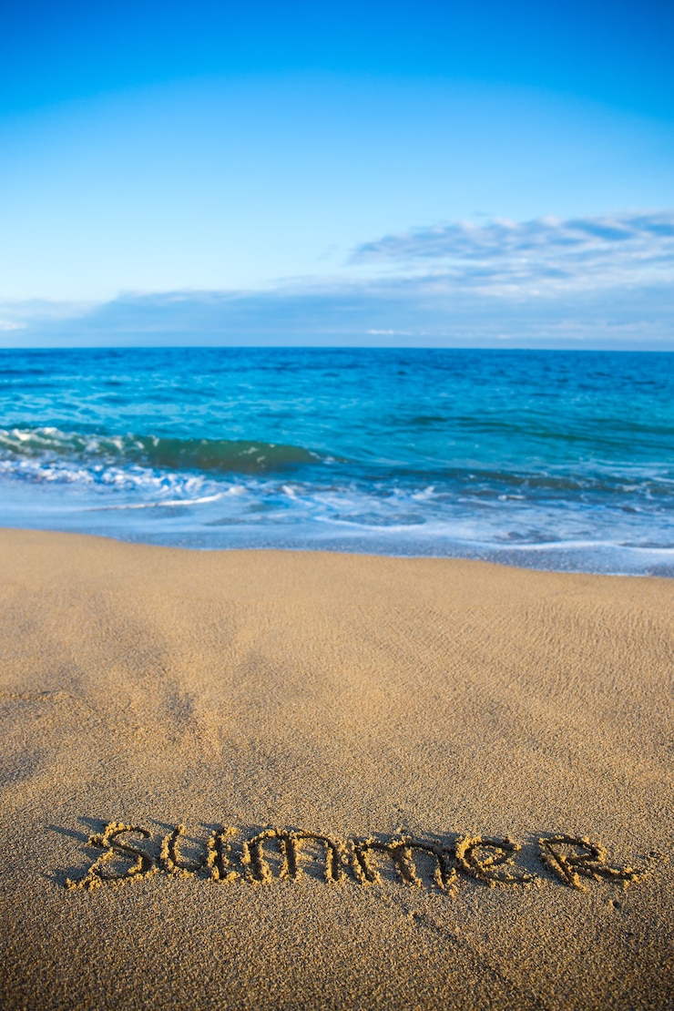Foto fondo soleggiato della spiaggia con l'estate di parola scritta in sand
