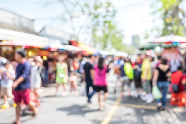 Fondo vago: la gente che compera al mercato giusto nel giorno soleggiato, fondo della sfuocatura con bokeh