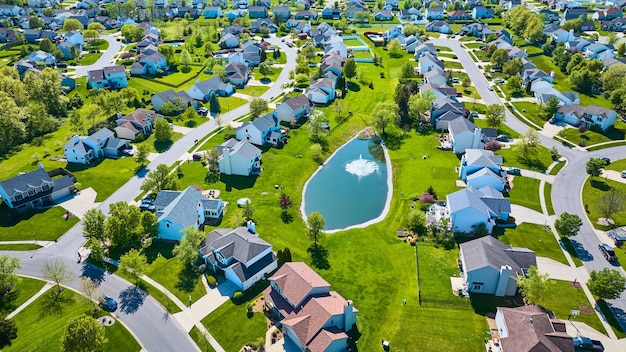 Fontana d'acqua in uno stagno blu in un grande quartiere suburbano pieno di case di varie dimensioni