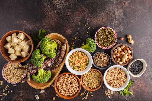 Fonte proteica vegana. Tofu, fagioli, ceci, noci e semi su uno sfondo scuro, vista dall&#39;alto, copia spazio.