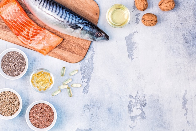 Fonti di omega 3: sgombro, salmone, semi di lino, semi di canapa, chia, noci, olio di semi di lino. Concetto di mangiare sano. Vista dall'alto con copia spazio.