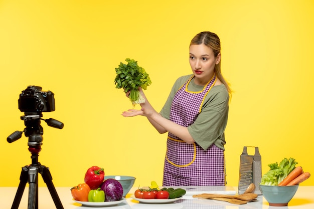 Food blogger adorabile chef in salute che registra video per i social media che tengono lattuga