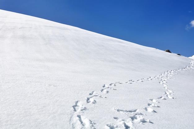 Footsprint sulla collina coperta di neve