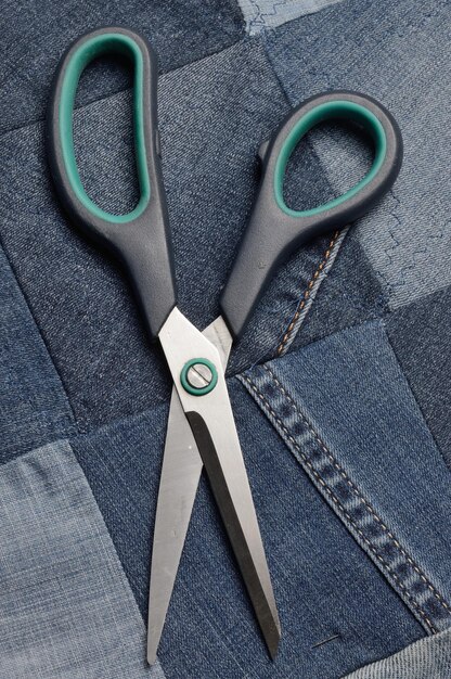 Forbici che si trovano sopra una tela cucita da pezzi di denim