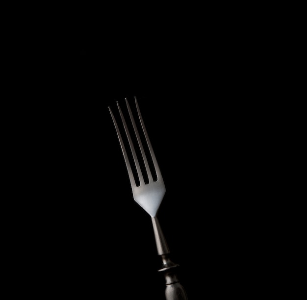 Forchetta da pranzo isolato su sfondo nero con copia spazio