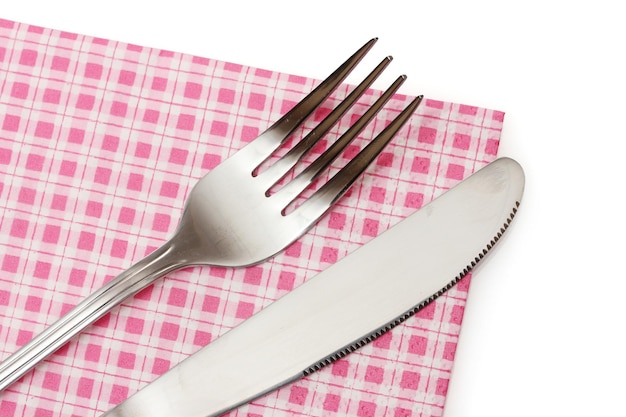 Forchetta e coltello in un panno plaid isolato su bianco