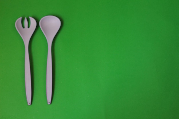 forchetta e cucchiaio bianchi su sfondo verde