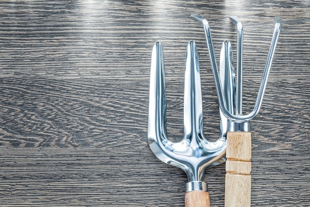 Forchetta per cazzuola con rastrello a mano su tavola di legno.