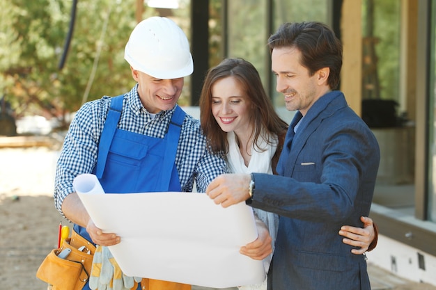 Foreman mostra a una giovane coppia il progetto di una casa