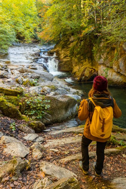 Foresta o giungla di Irati in autunno, una giovane donna alla cascata di Cubos. Ochagavia, Navarra settentrionale in Spagna