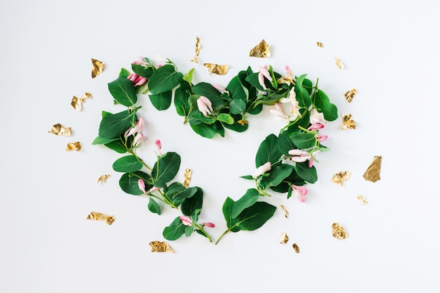 Forma di cuore fatta di fiori su bianco