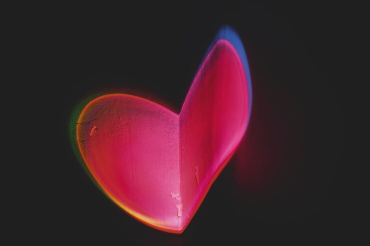Foto forma di cuore luminosa colorata proiettata in uno spazio negativo a parete