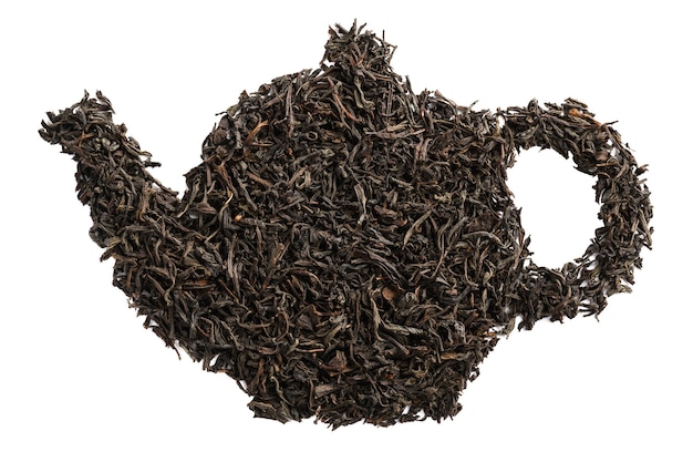 Forma di teiera in foglie di tè nero secche. Isolato.