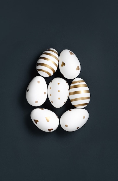 Forma di uovo di Pasqua bianco e oro su sfondo nero