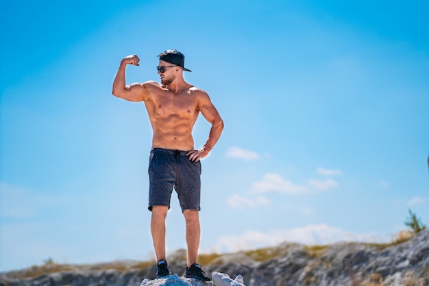 Forma maschile perfetta. Uomo forte e atletico in piedi con il torso nudo. Concetto di bel corpo sano.