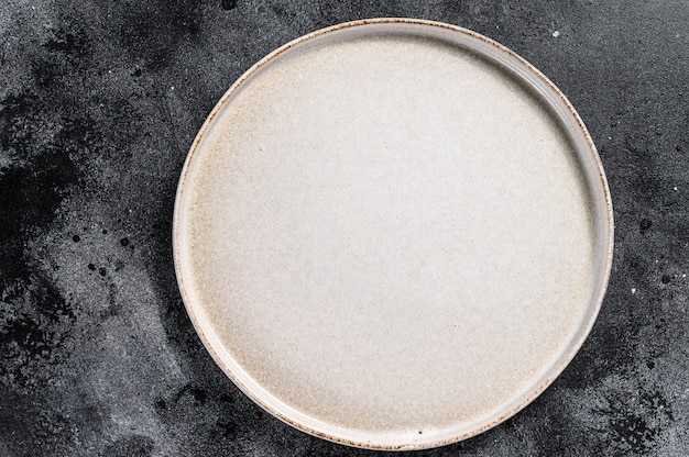 Forma rotonda del piatto bianco sulla tavola nera