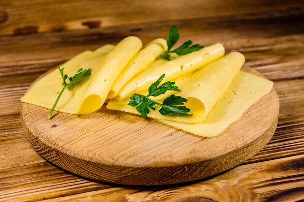 Formaggio a fette e prezzemolo su un tagliere di legno