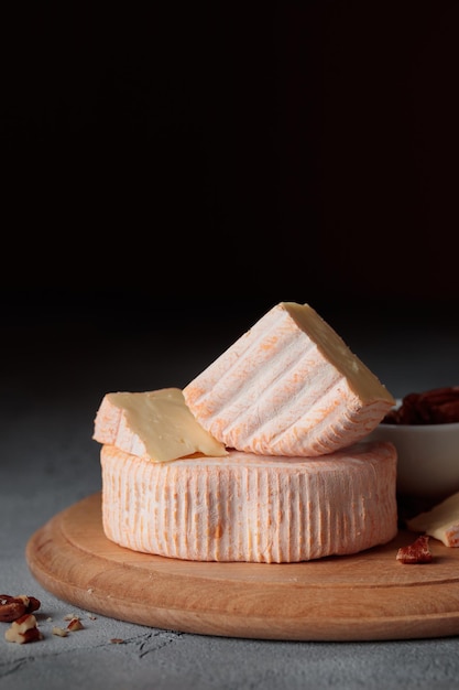 Formaggio a pasta molle affettato con lo stampo su una tavola di legno