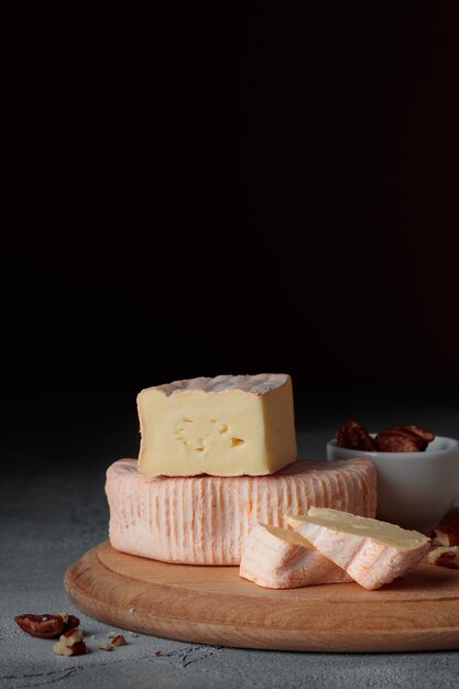 Formaggio a pasta molle affettato con lo stampo su una tavola di legno