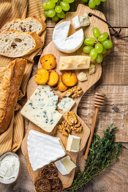 Formaggio assortito Brie, Camembert, Roquefort, parmigiano, crema di formaggio blu con uva, fichi, pane e noci.