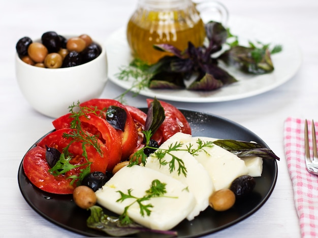 Formaggio bianco con pomodori, olive verdi e nere, basilico, coriandolo e olio d&#39;oliva