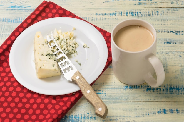 Formaggio blu e una tazza di caffè con latte