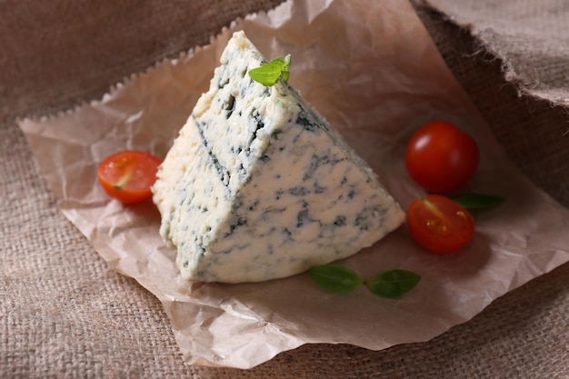 Formaggio blu gustoso con pomodori e basilico su sfondo di tela