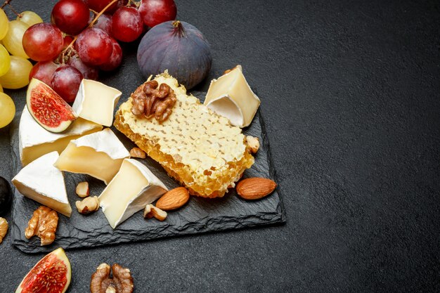 Formaggio Camembert con miele, fichi, noci su tavola di pietra