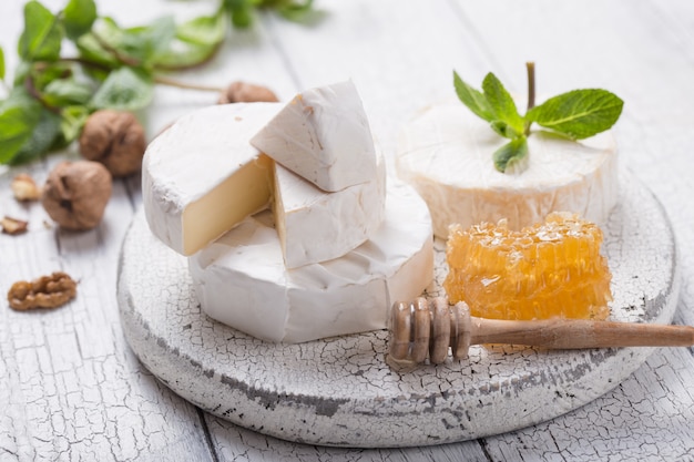 Formaggio Camembert su una tavola di legno con noci, miele e menta. Gourment italiano, francese