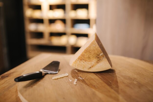 Formaggio con coltello di tavola di legno nel negozio di formaggi