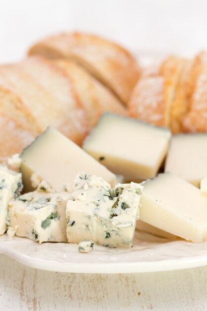 Formaggio con pane sul piatto bianco sulla tavola bianca