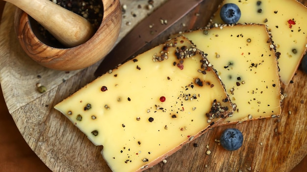 Formaggio con pepe nero su una tavola di legno