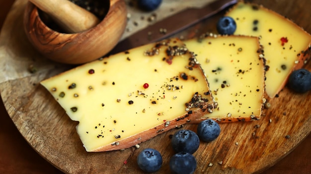 Formaggio con pepe nero su una tavola di legno