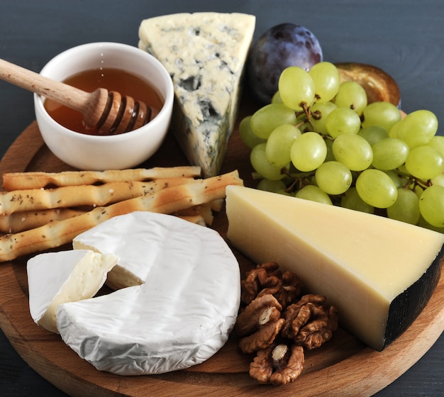 Formaggio da dessert, grissini, miele, noci e uva